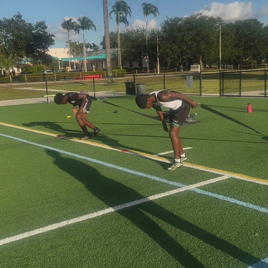Athlete performing resisted sprint training to build power and improve sprint start explosiveness