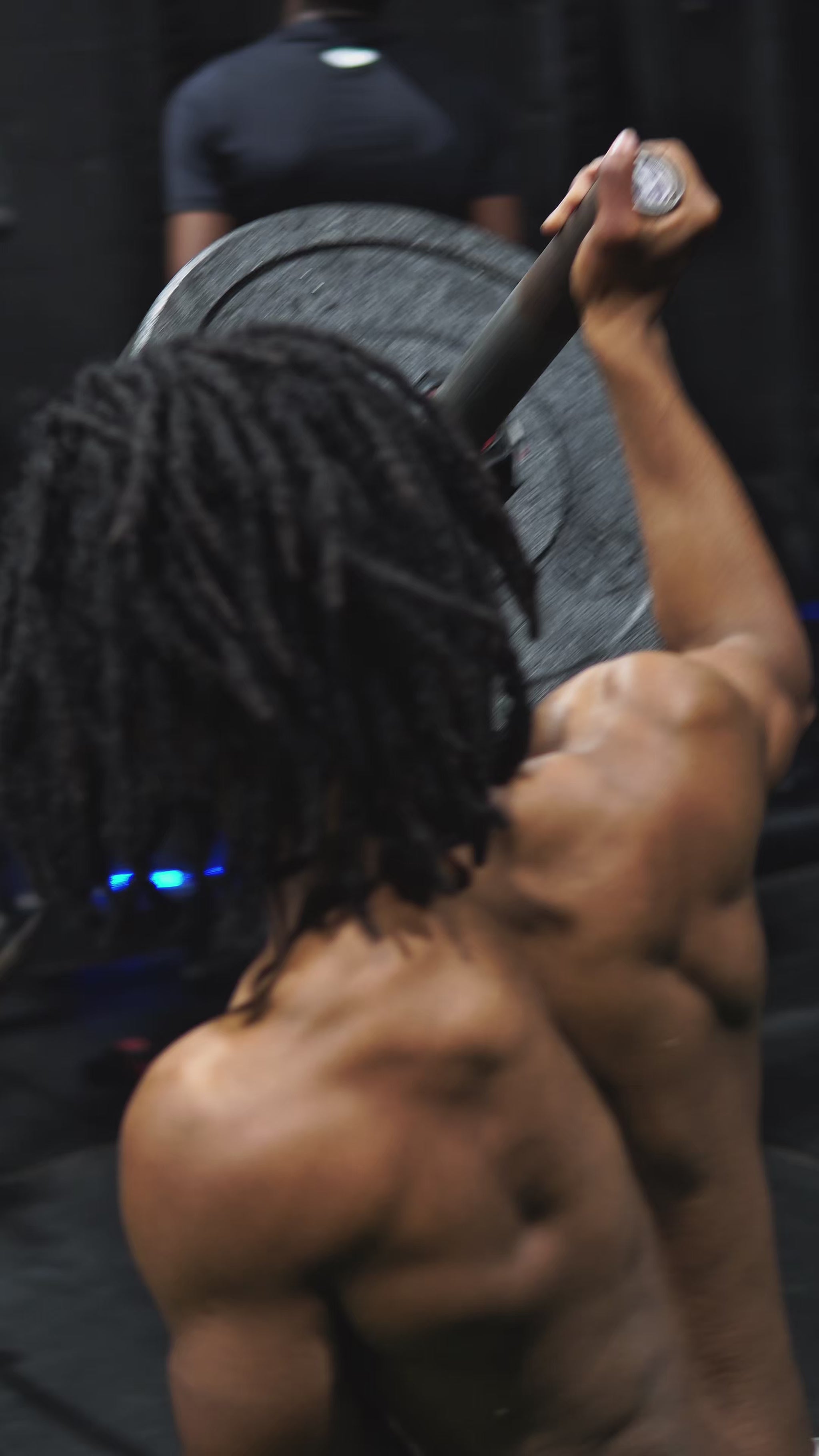 Indoor athletic facility with young participants engaged in fundamental movement training. Various stations blend strength and speed development through basic equipment and bodyweight exercises, emphasizing proper technique and gradual progression appropriate for developing athletes.